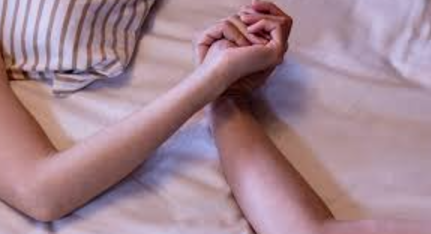 ベッドで手をつなぐ男女